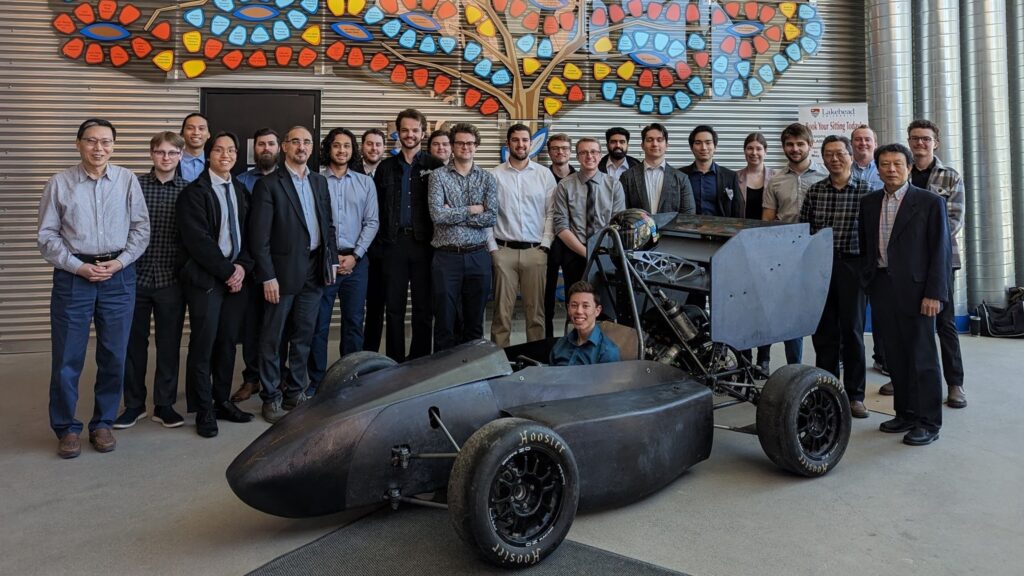 car at ATAC building with students and faculty